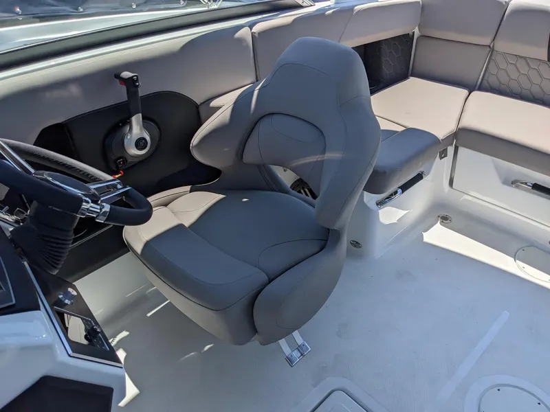 Slide: The Image of 2023 Four Winns H2 boat interior with captain's chair and seating area. - 16