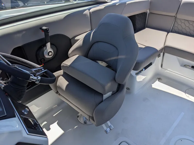 Slide: The Image of 2023 Four Winns H2 boat interior with captain's chair and steering wheel. - 17