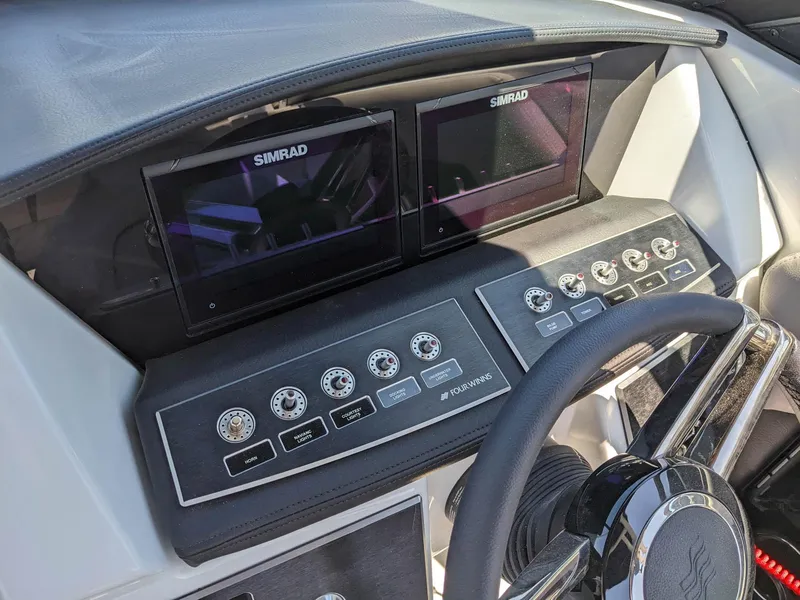 Slide: The Image of 2023 Four Winns H2 boat dashboard with dual Simrad displays and control panel. - 19