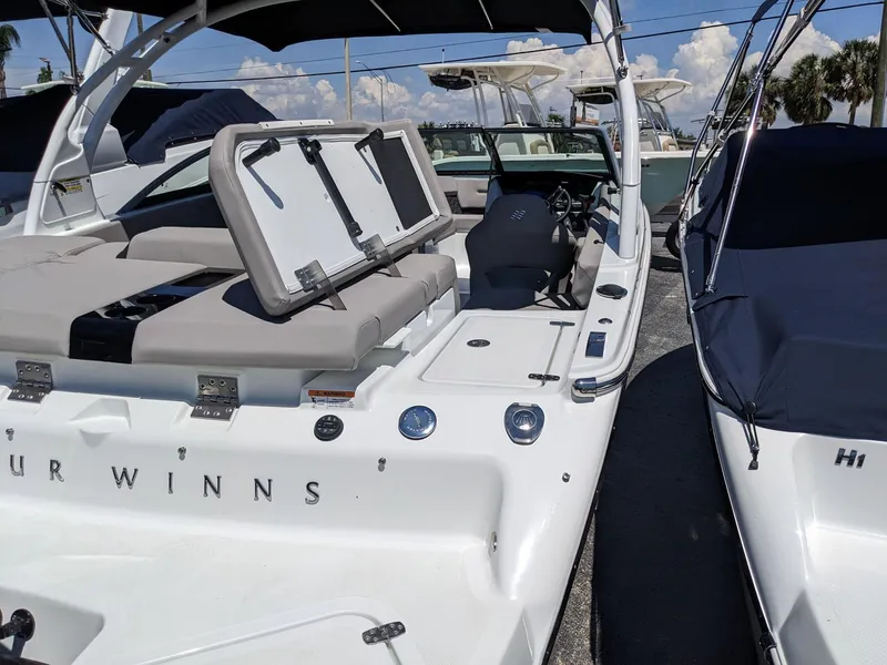 Slide: The Image of 2023 Four Winns H2 boat with open storage compartments and seating area. - 9