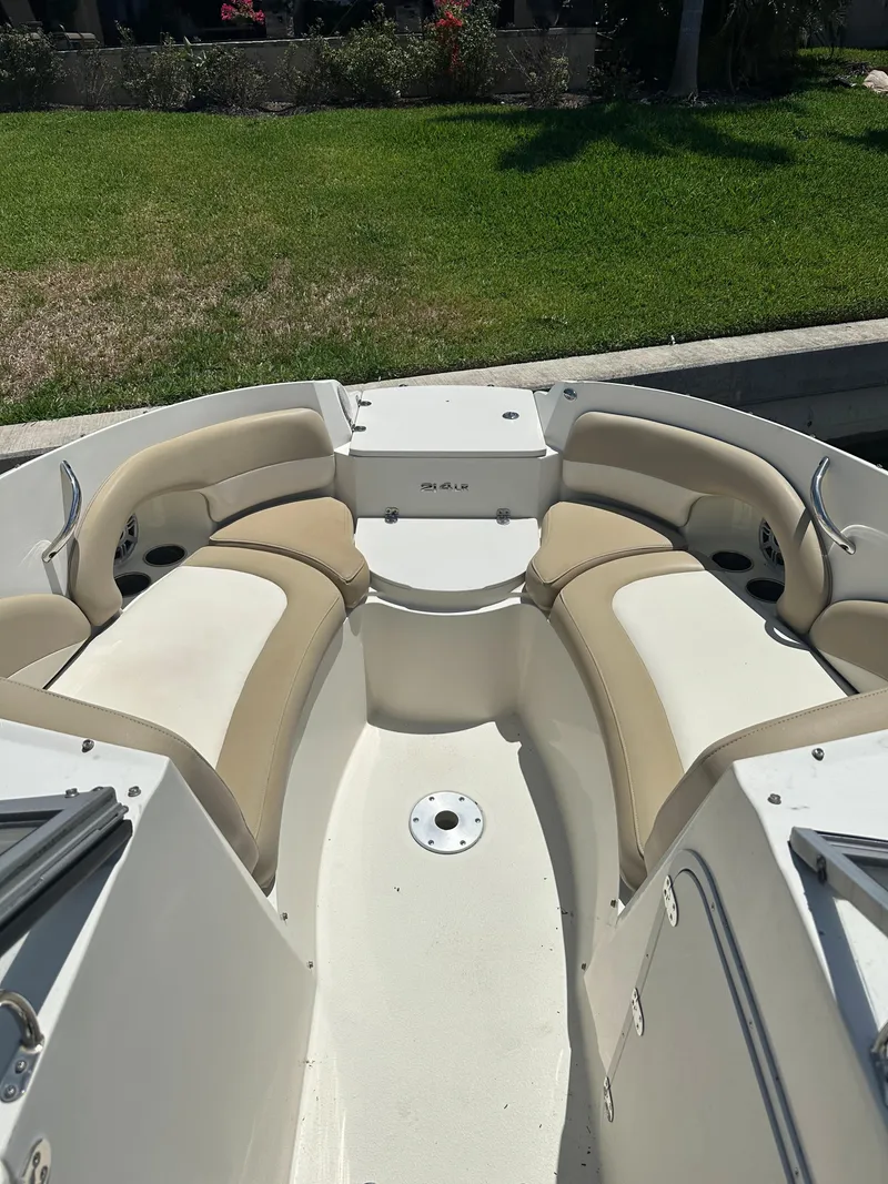 Slide: The Image of 2018 Stingray 214 LR boat interior with beige seating and white deck. - 11