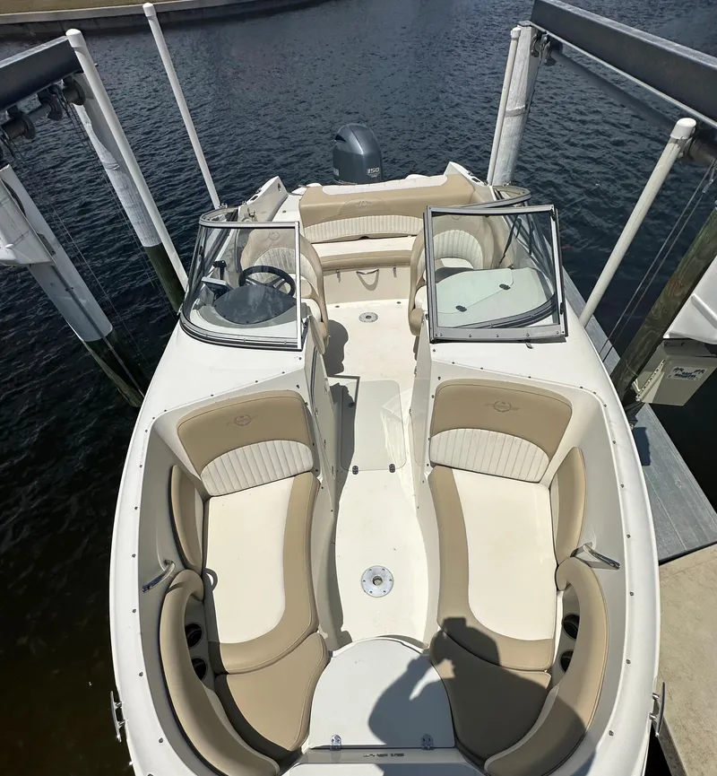 Slide: The Image of 2018 Stingray 214 LR boat with beige seating, docked on calm water. - 12