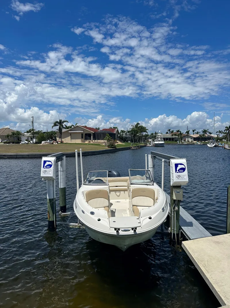 Slide: The Image of 2018 Stingray 214 LR boat docked on a sunny day with blue skies. - 4