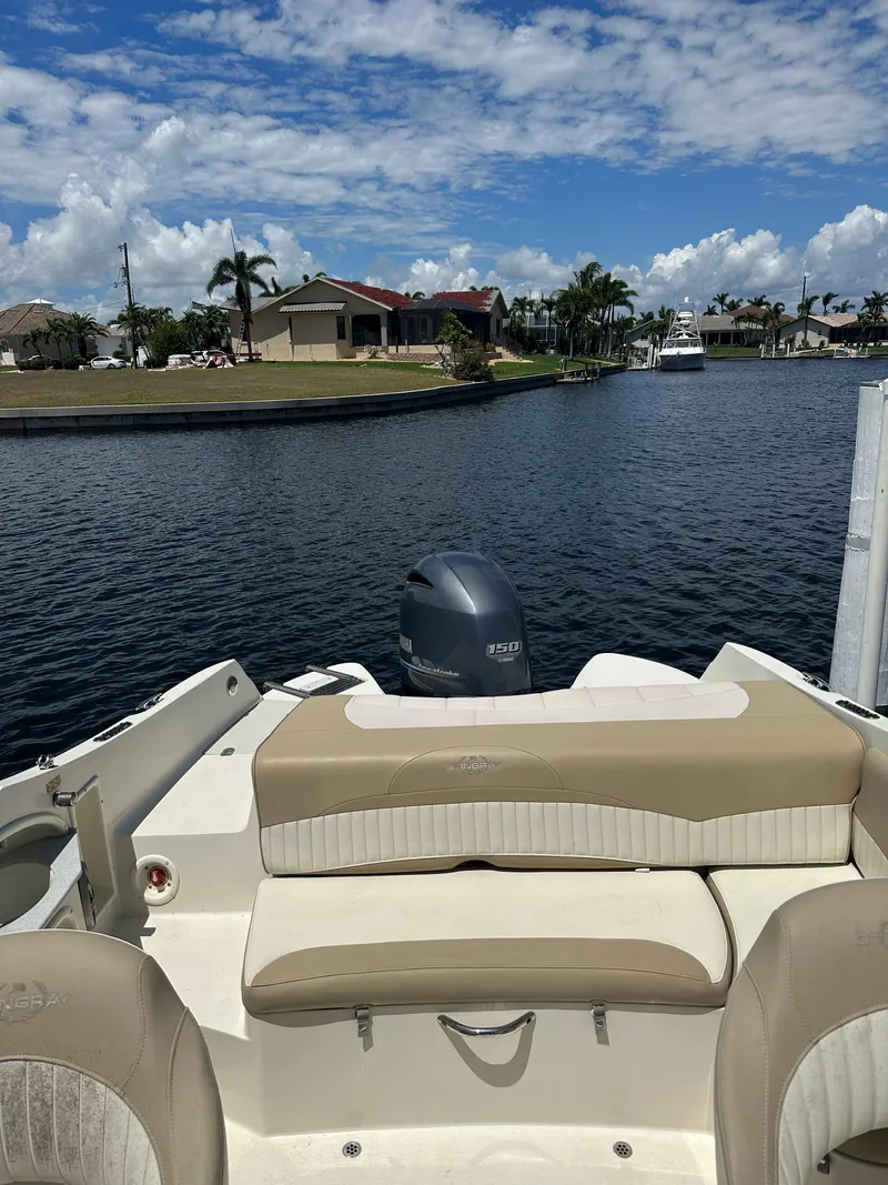 Slide: The Image of 2018 Stingray 214 LR boat on a calm waterway with clear skies. - 7