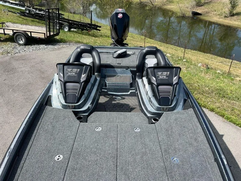 Slide: The Image of 2023 Nitro Z21 XL Pro bass boat on a lakeside road. - 6