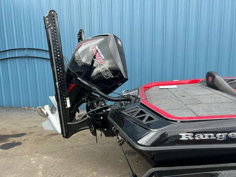 Slide: The Image of 2023 Ranger Z519 boat with powerful outboard motor, black and red design, parked near blue wall. - 5