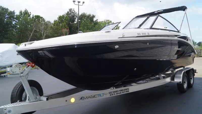 Slide: The Image of 2023 Hurricane SunDeck 235 OB boat on a trailer, black hull, outdoor setting. - 3