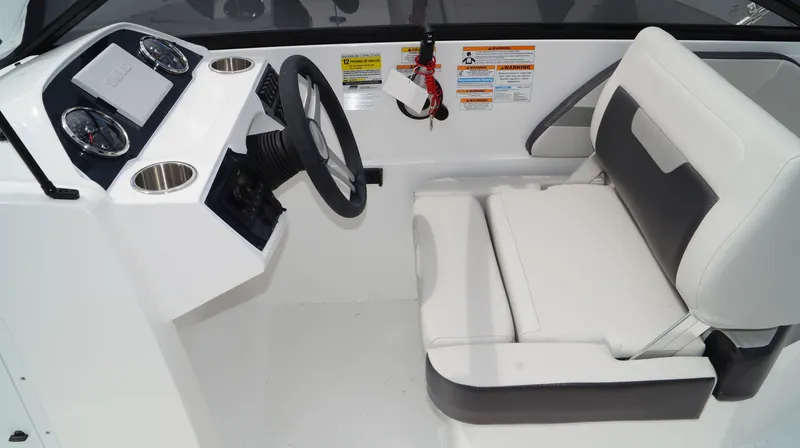 Slide: The Image of 2023 Hurricane SunDeck 235 OB boat cockpit with steering wheel and captain's chair. - 9