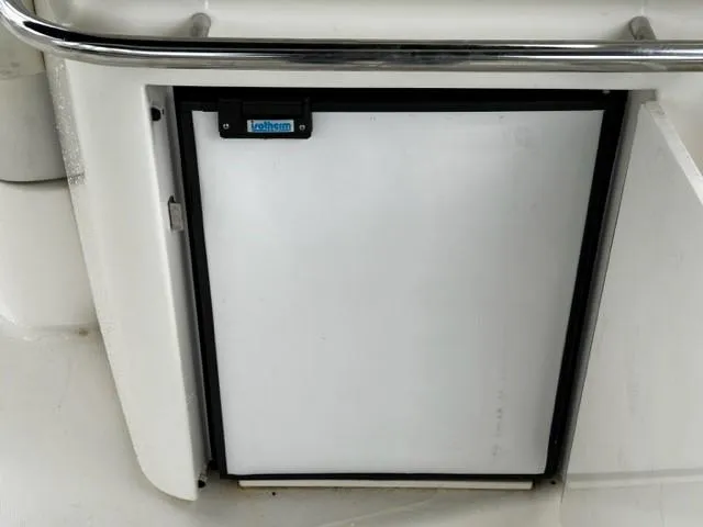Slide: The Image of Built-in refrigerator on a 2005 Cranchi 37 Smeraldo yacht, featuring a sleek white door. - 14