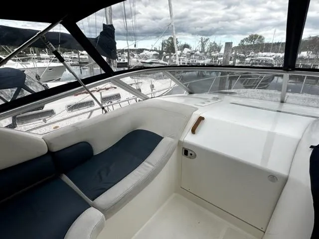 Slide: The Image of 2005 Cranchi 37 Smeraldo yacht interior with cushioned seating and marina view. - 16
