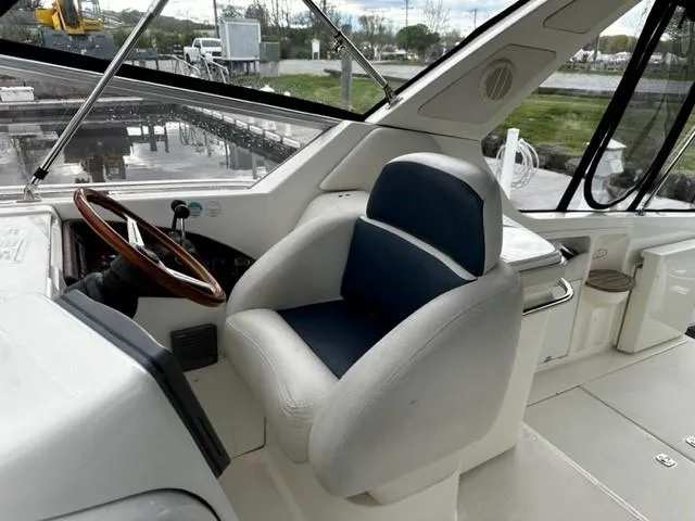 Slide: The Image of 2005 Cranchi 37 Smeraldo boat cockpit with steering wheel and cushioned seat. - 21