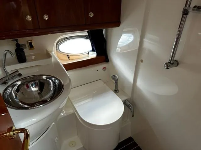 Slide: The Image of 2005 Cranchi 37 Smeraldo yacht bathroom with sink, toilet, and porthole window. - 22