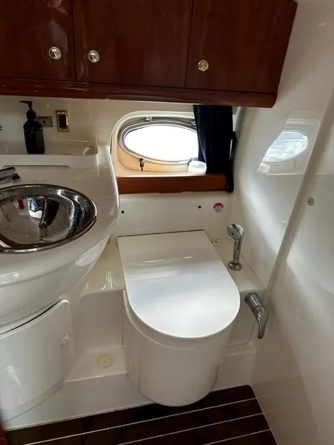 Slide: The Image of 2005 Cranchi 37 Smeraldo yacht bathroom with sink, toilet, and porthole window. - 25