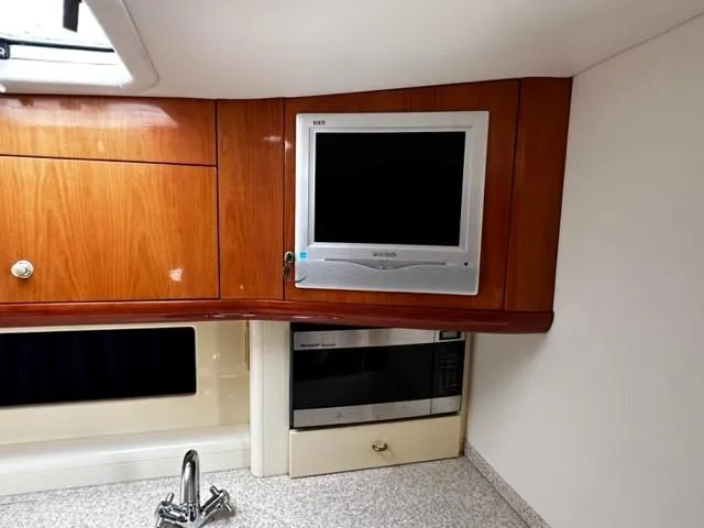 Slide: The Image of Interior of 2005 Cranchi 37 Smeraldo yacht with TV, microwave, and wooden cabinetry. - 26