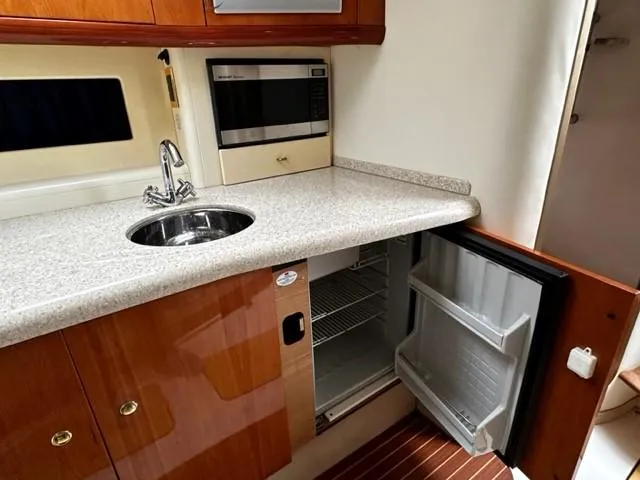 Slide: The Image of 2005 Cranchi 37 Smeraldo yacht kitchen with sink, microwave, and open fridge. - 27