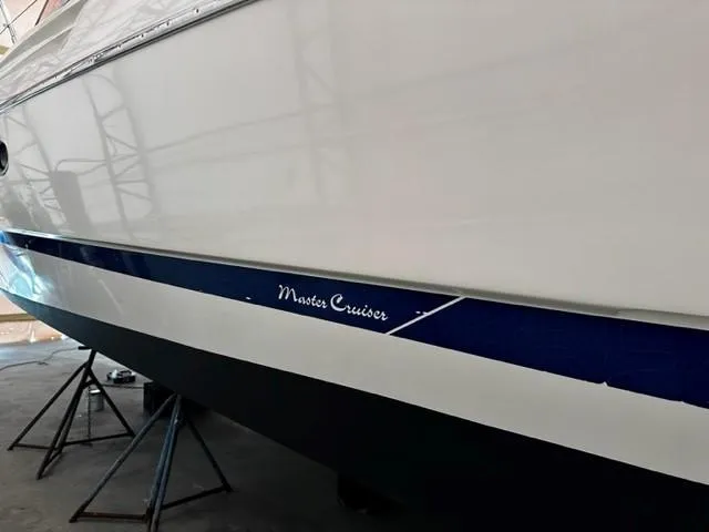 Slide: The Image of 2005 Cranchi 37 Smeraldo boat hull with "Master Cruiser" text, displayed on stands. - 49