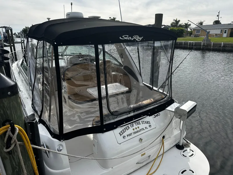 Slide: The Image of 2001 Sea Ray 340 Sundancer docked, featuring enclosed cockpit and Keeper of the Stars nameplate. - 12