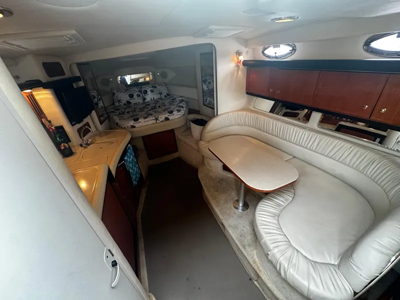 Slide: The Image of Interior of 2001 Sea Ray 340 Sundancer with seating, table, and sleeping area. - 31