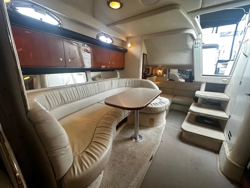 Slide: The Image of Interior of 2001 Sea Ray 340 Sundancer with beige leather seating and wooden cabinets. - 32