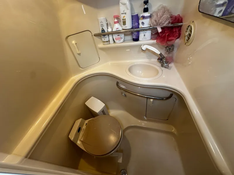 Slide: The Image of Compact bathroom in 2001 Sea Ray 340 Sundancer yacht with sink, toilet, and toiletries. - 42