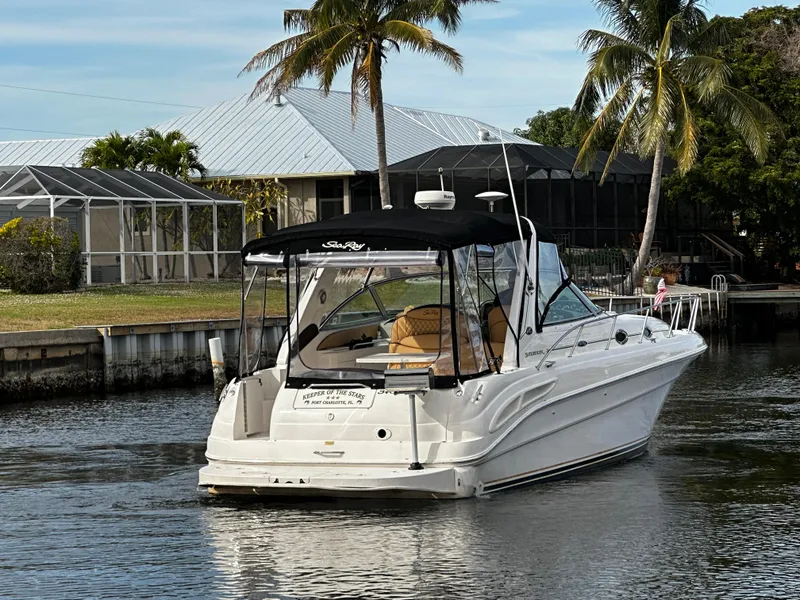 Slide: The Image of 2001 Sea Ray 340 Sundancer boat docked near waterfront homes with palm trees. - 7