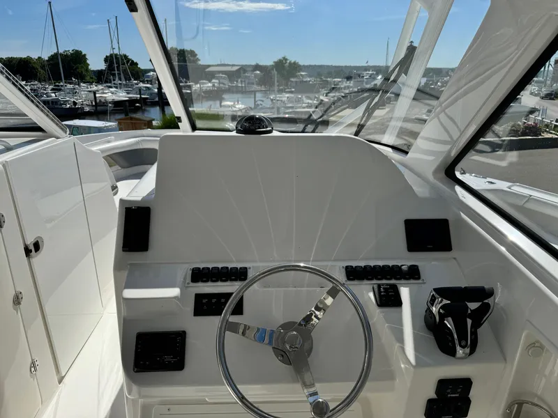 Slide: The Image of 2023 Albemarle 31 Dual Console boat helm with steering wheel and control panel. - 5