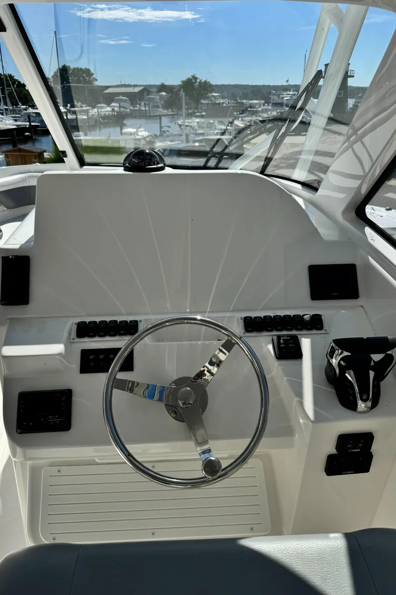 Slide: The Image of 2023 Albemarle 31 Dual Console boat helm with steering wheel and controls. - 6