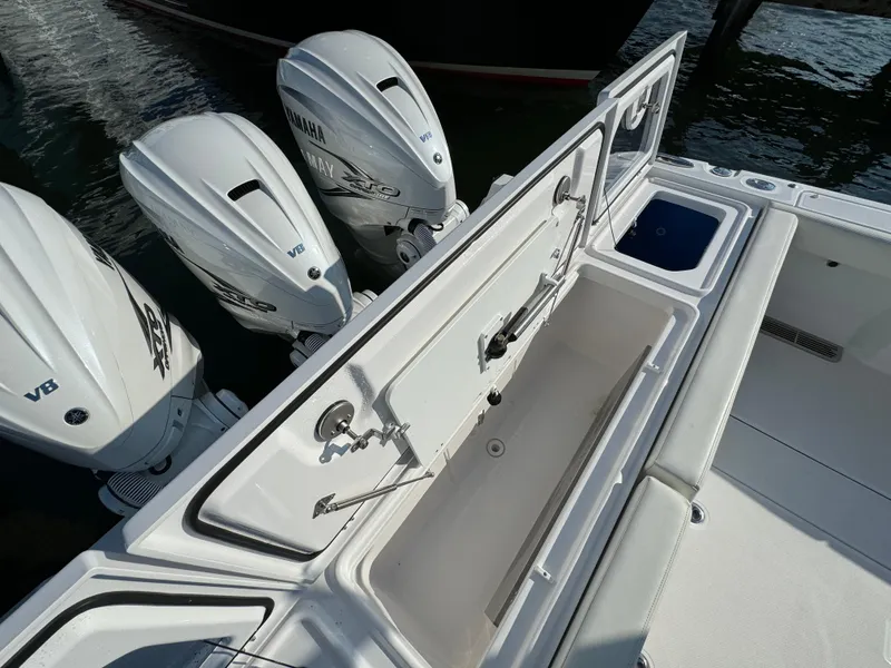 Slide: The Image of 2024 Everglades 395 Center Console with triple Yamaha V8 engines, open storage compartment. - 18