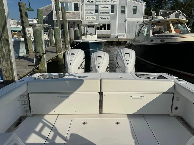 Slide: The Image of 2024 Everglades 395 Center Console boat docked with triple outboard engines. - 20