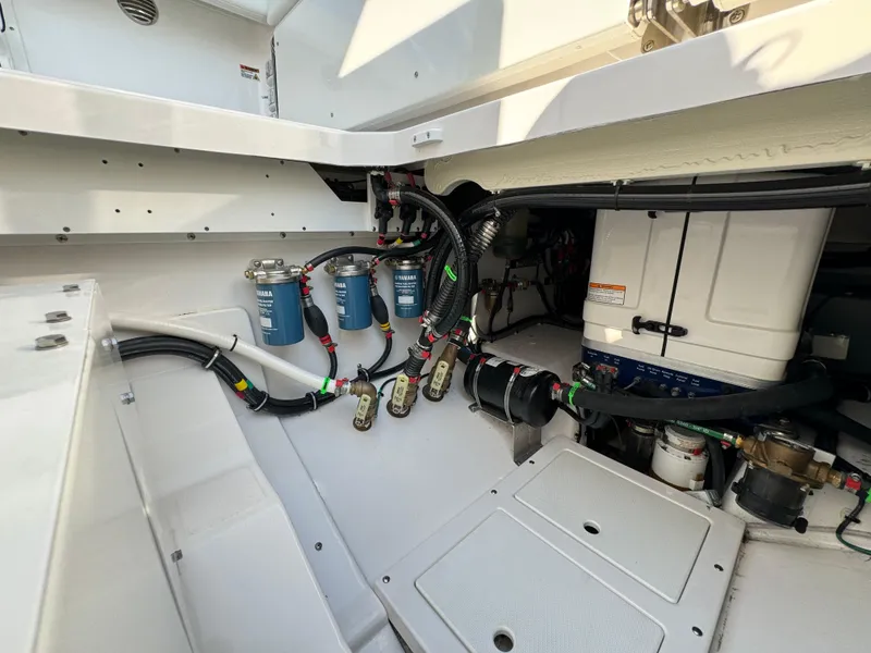 Slide: The Image of 2024 Everglades 395 Center Console engine compartment with fuel filters and wiring. - 27