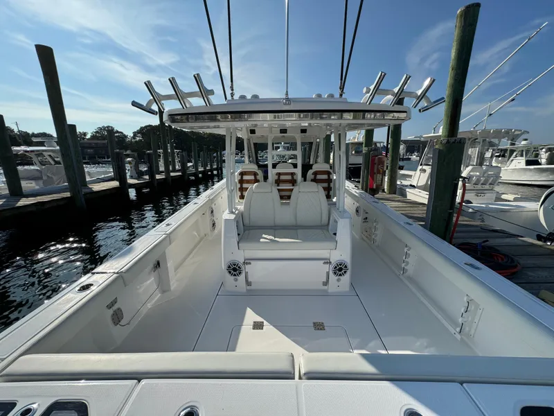Slide: The Image of 2024 Everglades 395 Center Console boat docked, showcasing spacious deck and seating. - 29