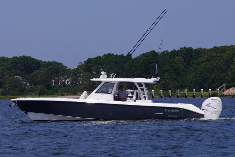 Slide: The Image of 2024 Everglades 395 Center Console boat cruising on a lake with forested shoreline. - 3