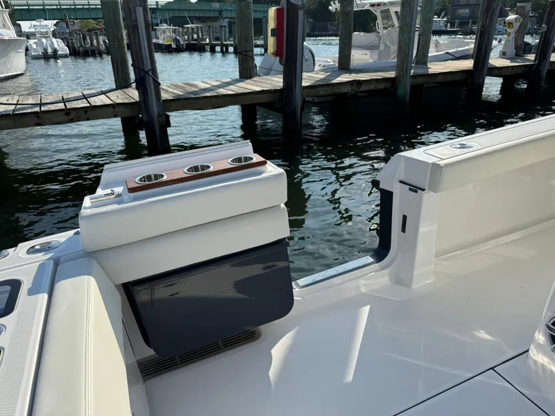 Slide: The Image of 2024 Everglades 395 Center Console boat docked at marina, featuring sleek design and cup holders. - 33
