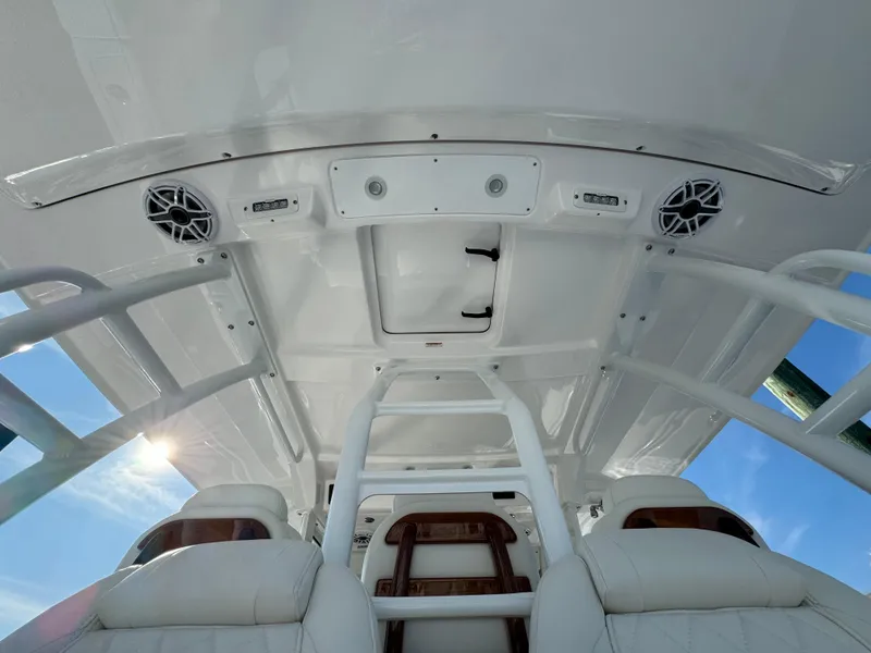 Slide: The Image of 2024 Everglades 395 Center Console boat interior with white seating and overhead speakers. - 45