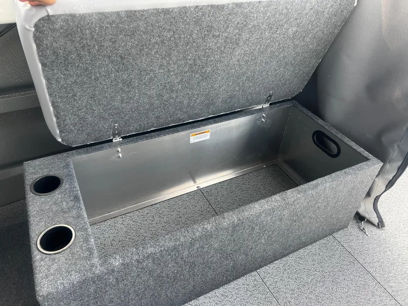 Slide: The Image of 2023 Thunder Jet 21 Chinook OS storage compartment with cup holders and carpeted interior. - 14