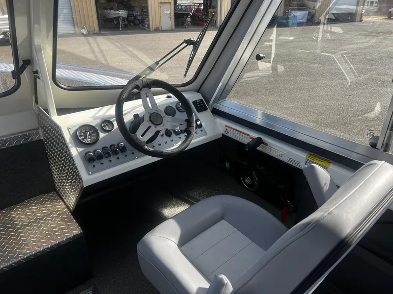 Slide: The Image of 2023 Thunder Jet 21 Chinook OS boat interior with steering wheel and controls. - 9