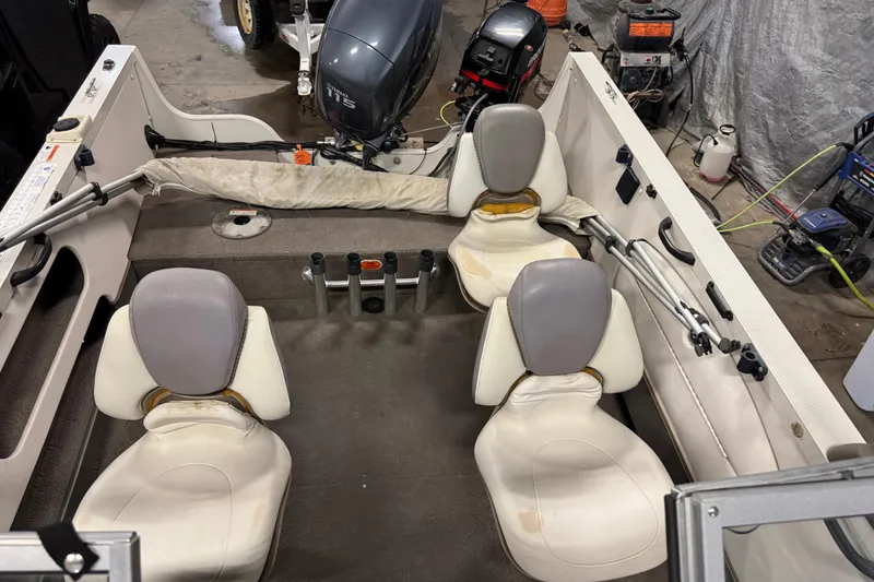 Slide: The Image of 2004 Crestliner 1700 SUPER HAWK interior with four seats and outboard motor in a garage. - 16