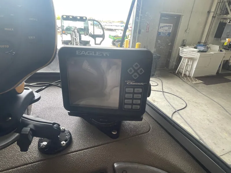 Slide: The Image of 2004 Crestliner 1700 SUPER HAWK boat with dual outboard motors in a garage setting. - 6