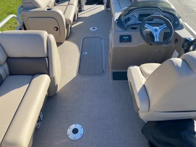 Slide: The Image of 2023 Sun Tracker SportFish 22 XP3 boat interior with beige seating and steering console. - 4