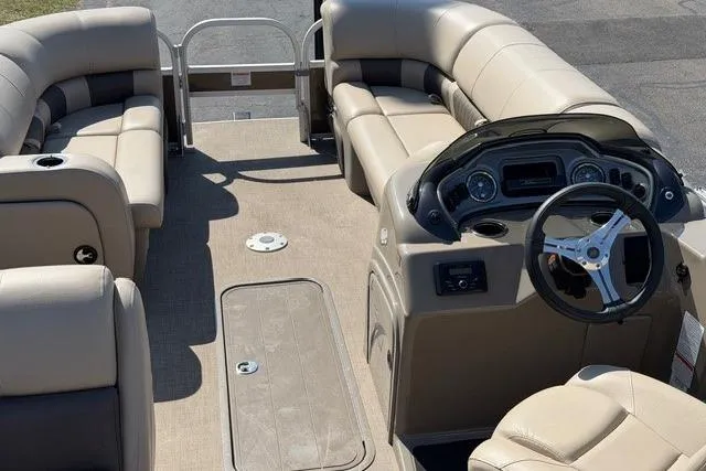 Slide: The Image of 2023 Sun Tracker SportFish 22 XP3 pontoon boat interior with beige seating and steering console. - 5