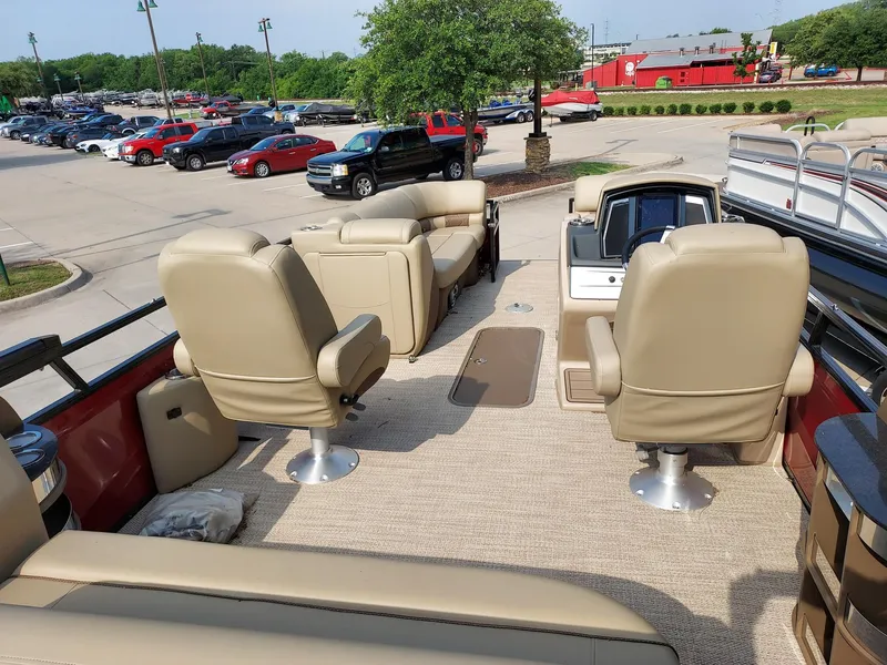 Slide: The Image of 2023 Regency 230 LE3 Sport boat interior with beige seating and carpet. - 2