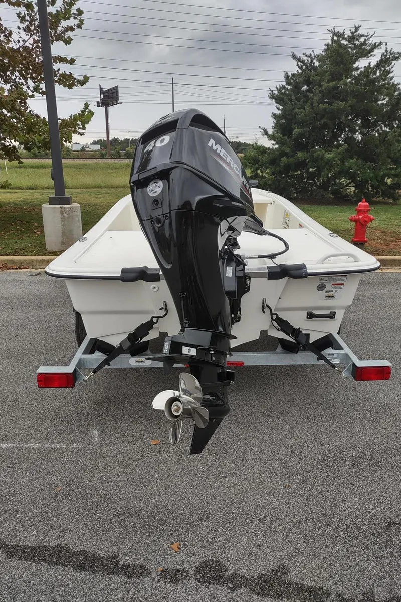 Slide: The Image of 2023 Mako Pro Skiff 13 CC boat with outboard motor on trailer. - 3
