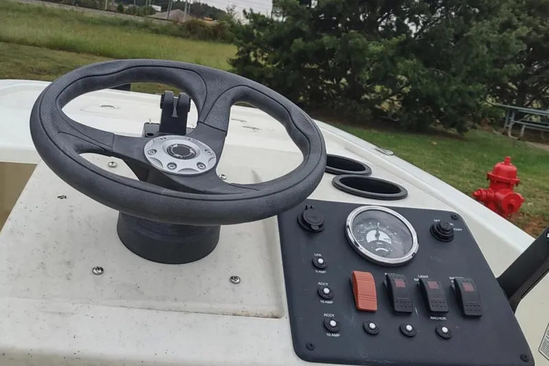 Slide: The Image of 2023 Mako Pro Skiff 13 CC steering console with controls and gauges. - 4