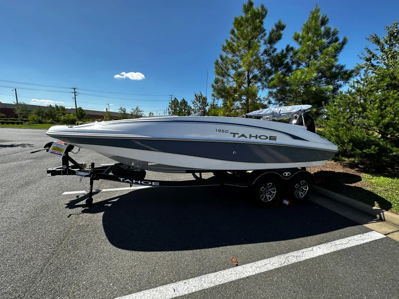 The Image of 2023 Tahoe 1950 boat on a trailer in a parking lot. - 0