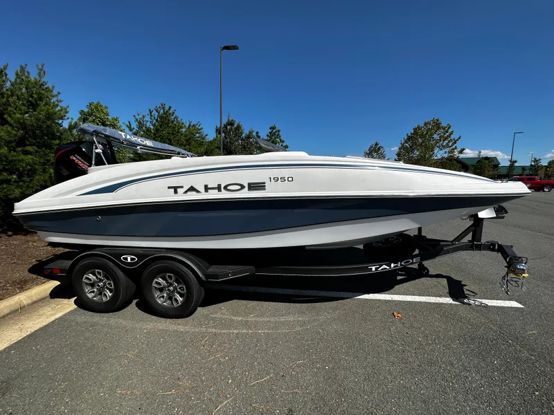 Slide: The Image of 2023 Tahoe 1950 boat on a trailer in a parking lot. - 1