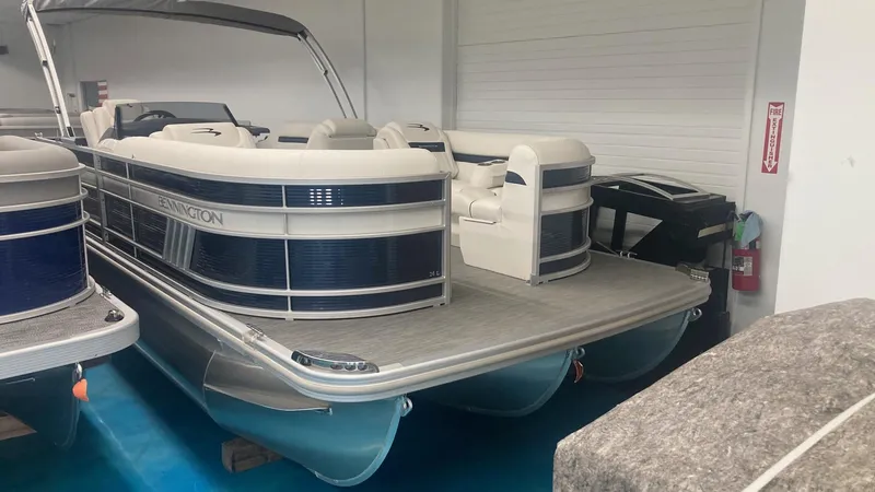 Slide: The Image of 2023 Bennington 24 LXSB pontoon boat in showroom. - 2