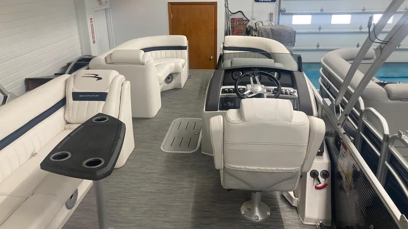 Slide: The Image of 2023 Bennington 24 LXSB pontoon boat interior with white seating and helm station. - 3