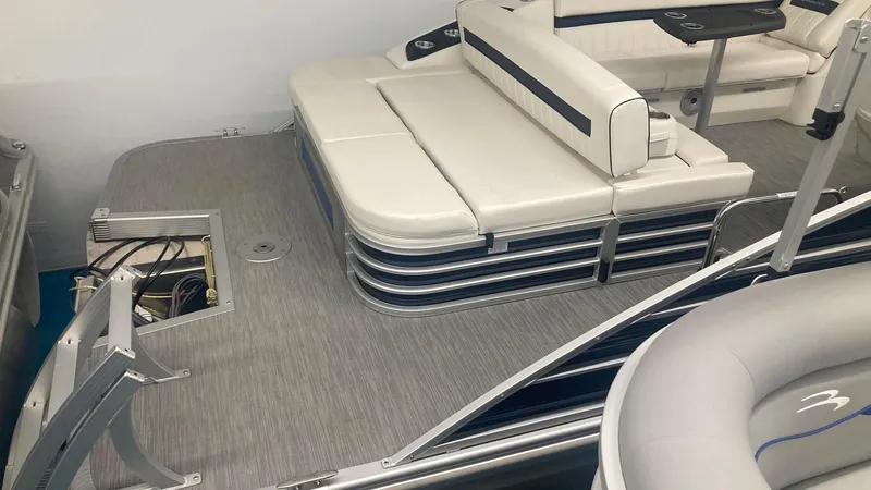 Slide: The Image of 2023 Bennington 24 LXSB pontoon boat interior with white seating and gray flooring. - 4