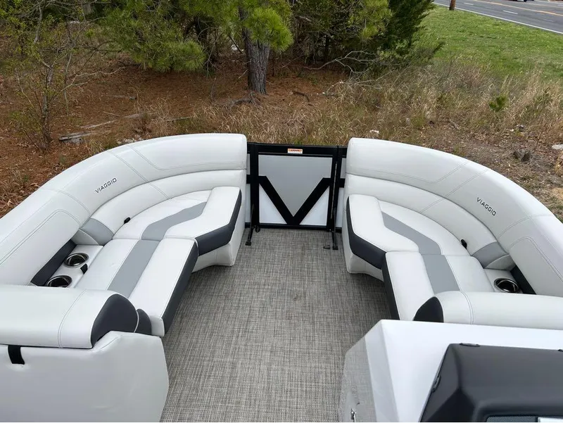 Slide: The Image of 2023 Viaggio D23U boat interior with white and gray seating, cup holders, and carpeted flooring. - 13