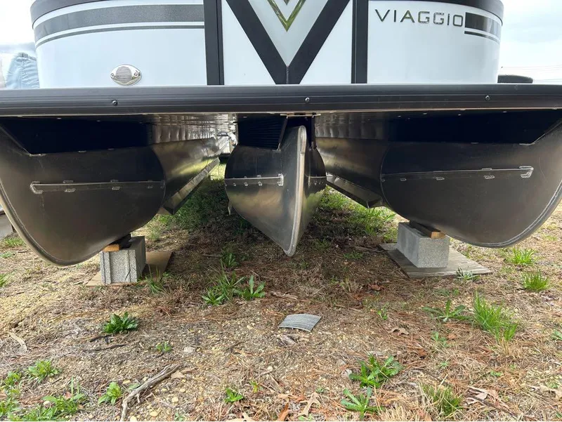 Slide: The Image of 2023 Viaggio D23U pontoon boat on blocks, showcasing undercarriage and pontoons. - 6